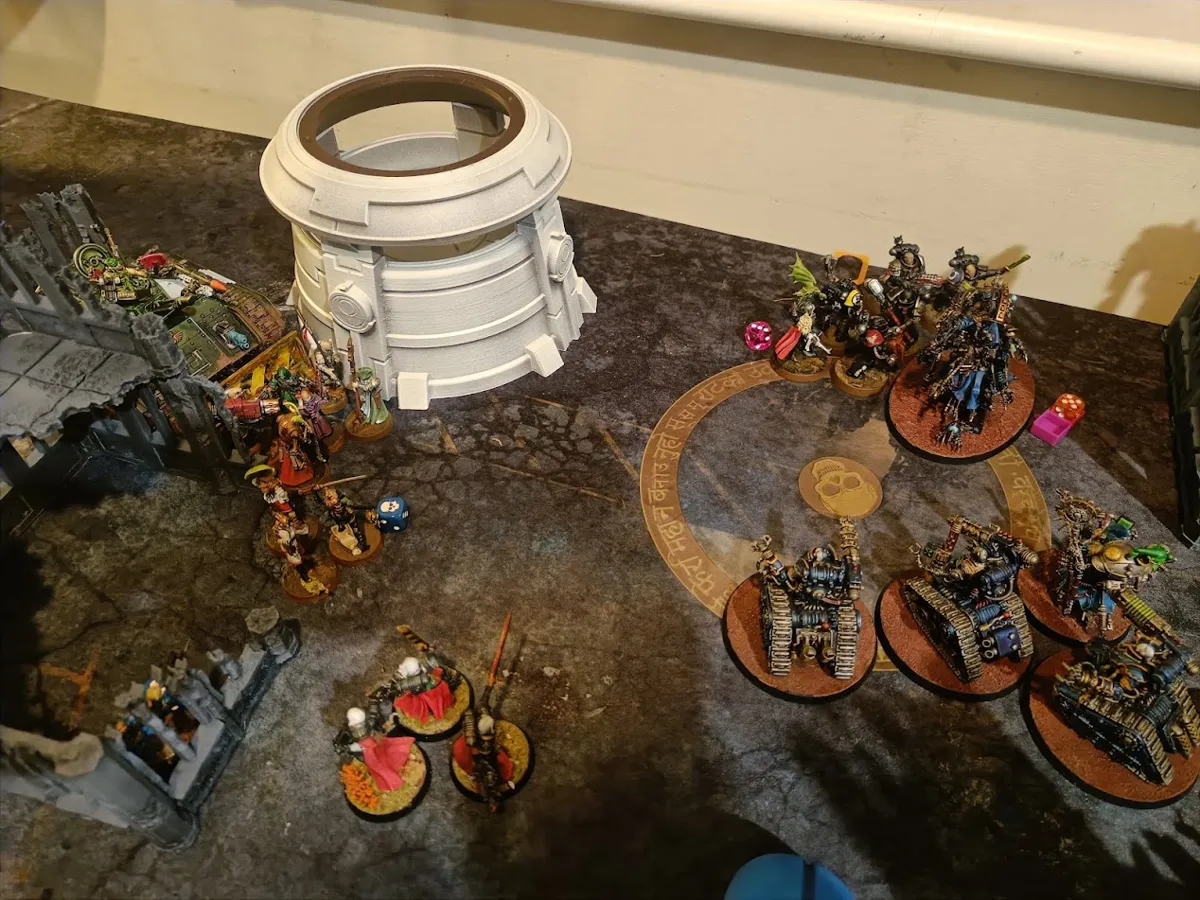 Blue Adeptus Mechanicus models on an objective during a game of Warhammer 40,000