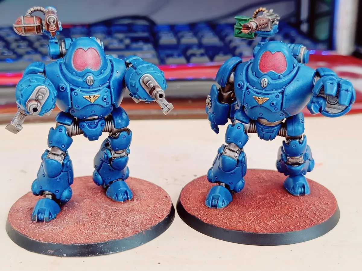 Two Kastelan Robots painted in bright blue with red visors