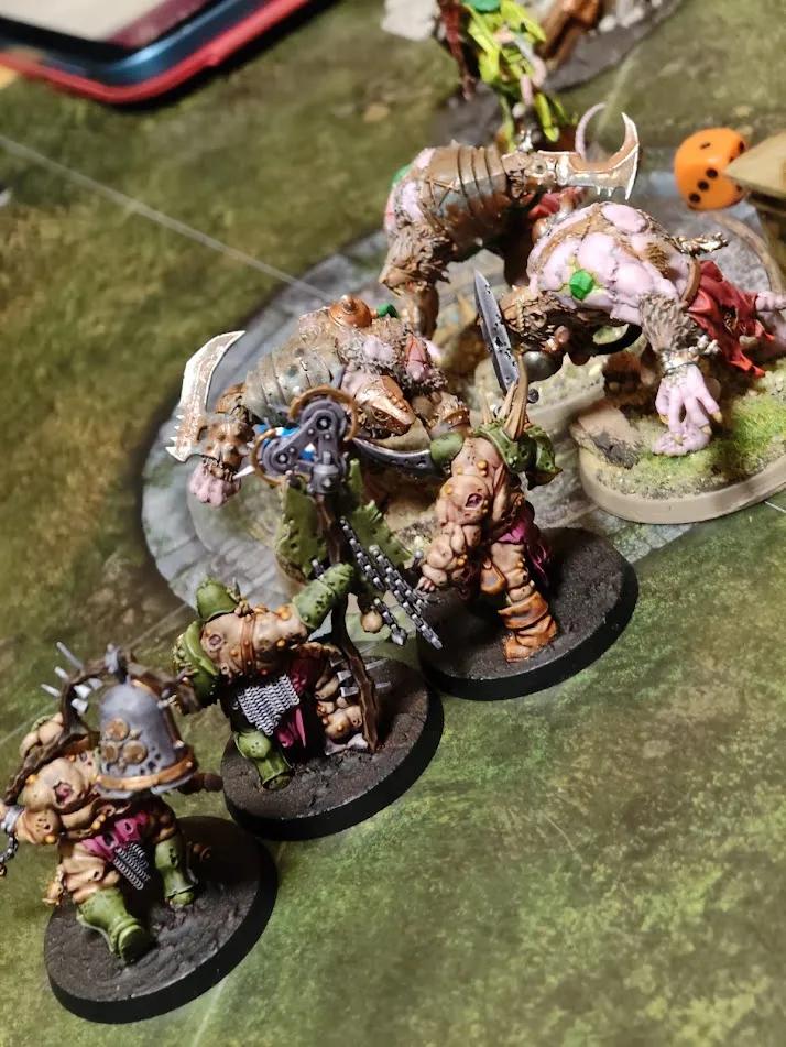 Painted Nurgle and Ogor models in close-up on a green gaming mat